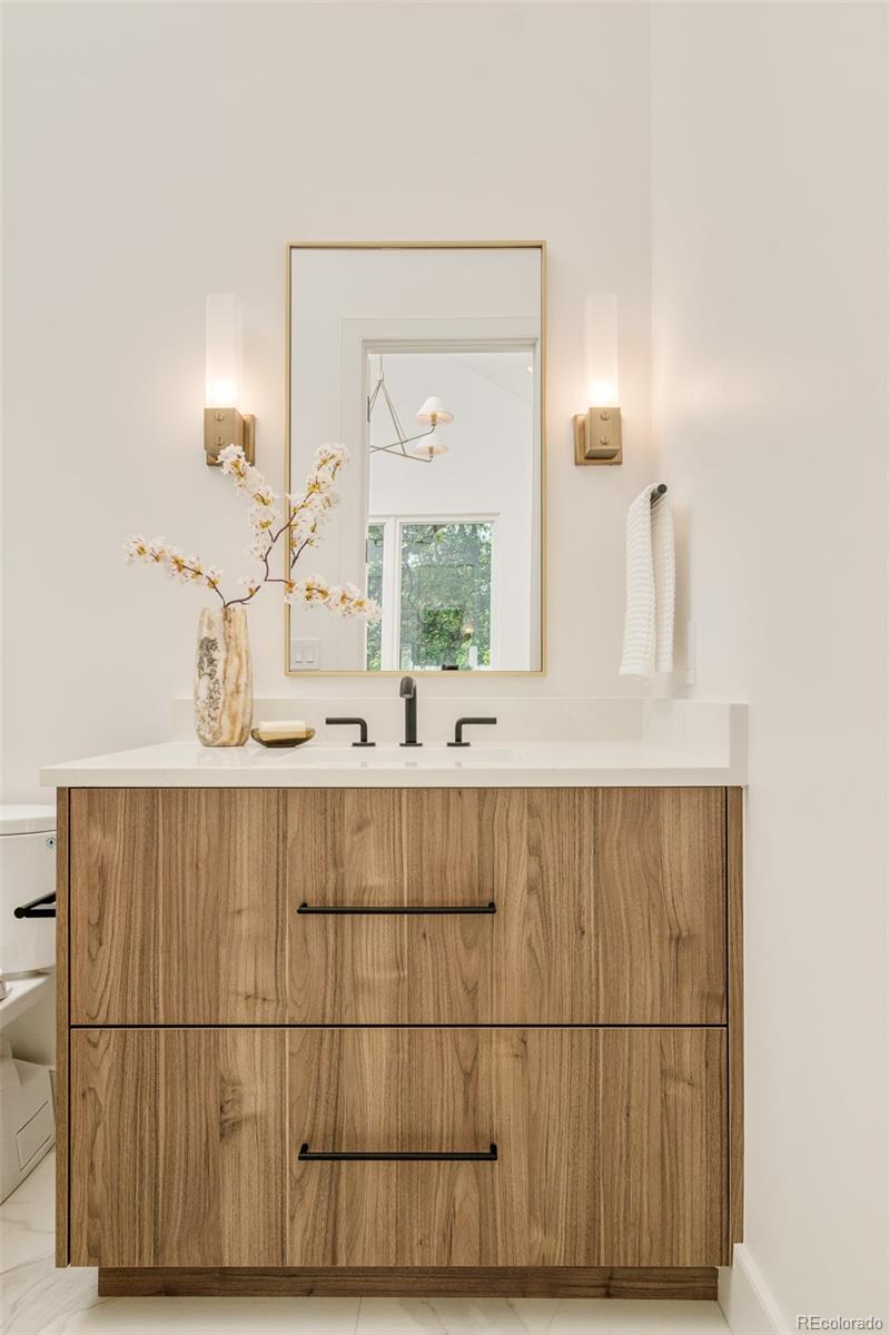 1253 South High Street Denver, CO 80210 - Photo 32 of 46 a bathroom with a sink mirror and vanity