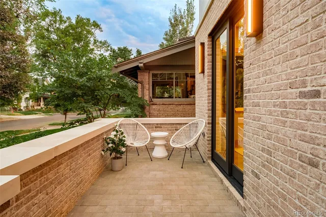 a view of a patio with table and chairs with wooden floor and fence