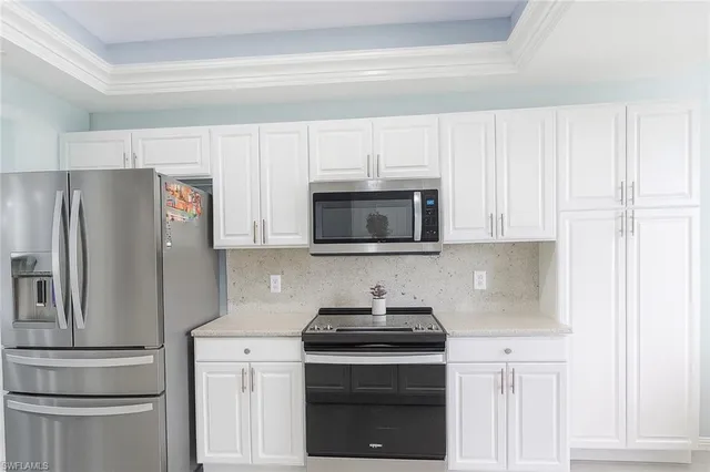 a kitchen with stainless steel appliances white cabinets and a stove