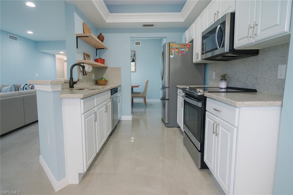 1320 Henley Street, Unit 2003 Naples, FL 34105 - Photo 3 of 36 a kitchen with stainless steel appliances granite countertop a sink and a stove top oven
