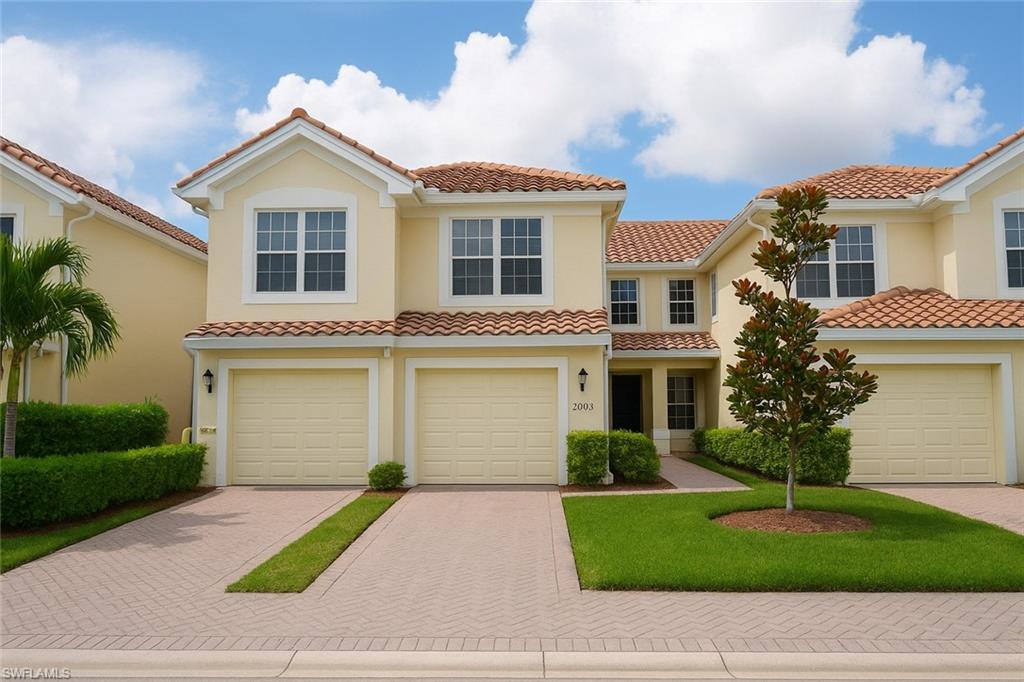 1320 Henley Street, Unit 2003 Naples, FL 34105 - Photo 34 of 36 a front view of a house with a garden and garage