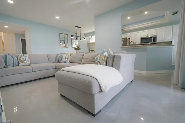 a living room with furniture and a kitchen