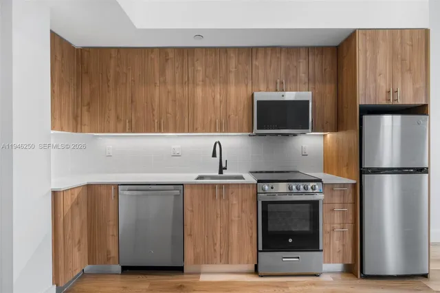 a kitchen with stainless steel appliances a stove a microwave and a refrigerator