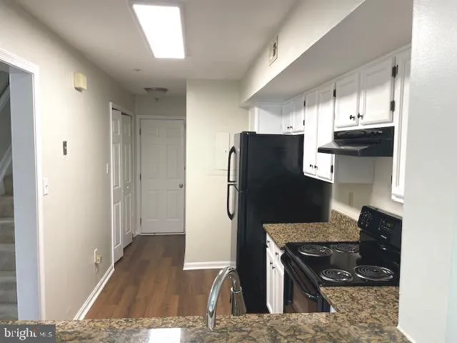 a kitchen with stainless steel appliances granite countertop a refrigerator and a stove