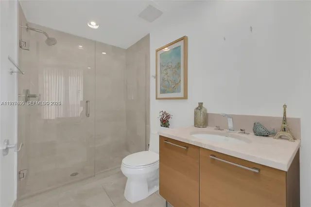 a bathroom with a granite countertop sink a toilet and shower