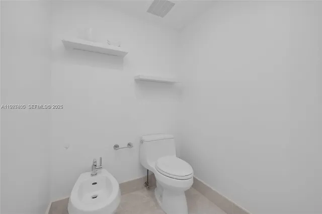 a white toilet sitting next to a shower
