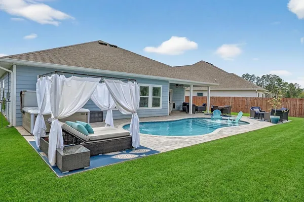 a view of house with backyard and outdoor seating
