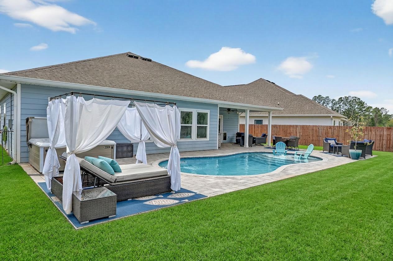 a view of house with backyard and outdoor seating