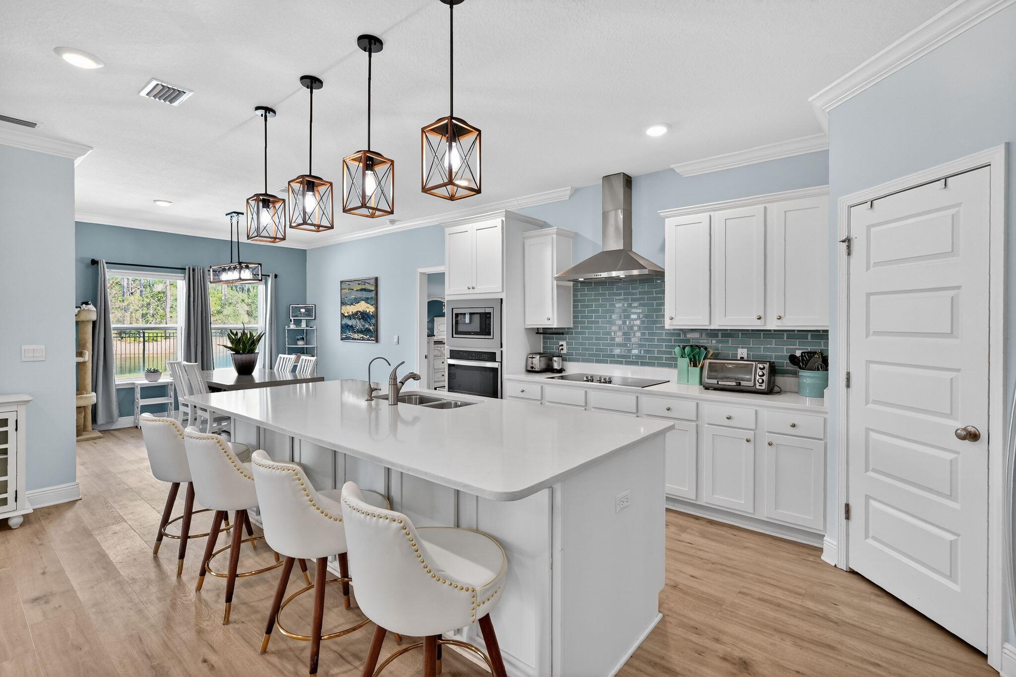 27 Oak Trees Lane East Freeport, FL 32439 - Photo 9 of 33 a large kitchen with white cabinets and wooden floor