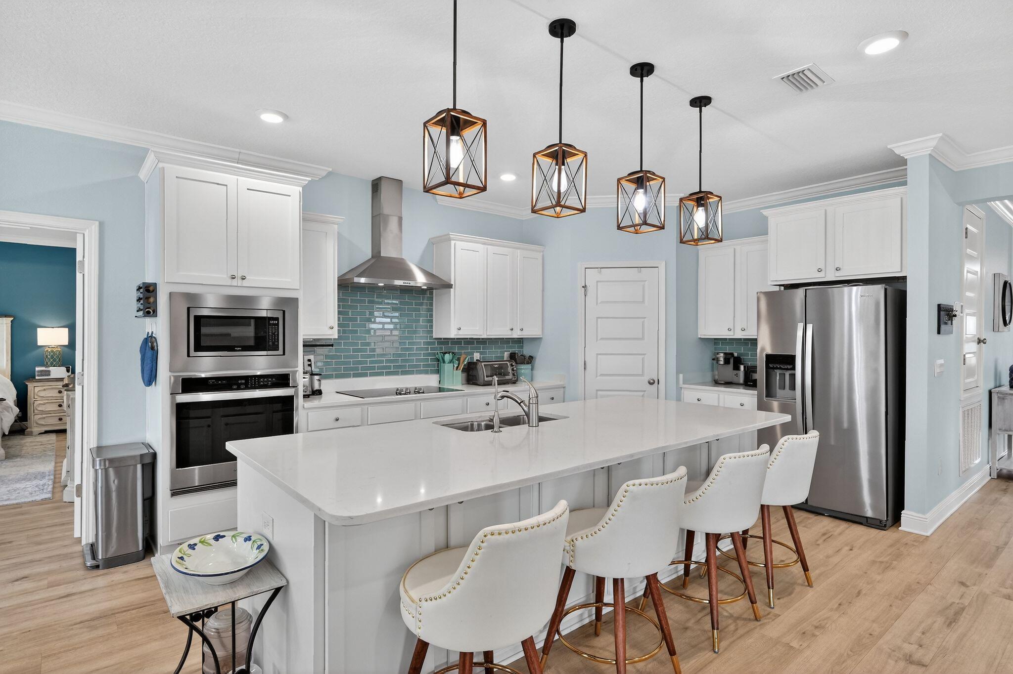 27 Oak Trees Lane East Freeport, FL 32439 - Photo 10 of 33 a kitchen with stainless steel appliances a dining table chairs stove and refrigerator