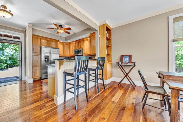 a view of a dining room with furniture a chandelier and wooden floor