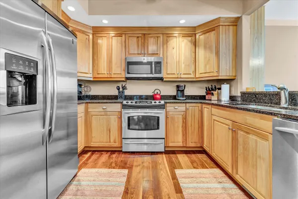 a kitchen with granite countertop a sink stainless steel appliances and cabinets