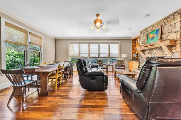 a view of a dining room with furniture a rug and wooden floor