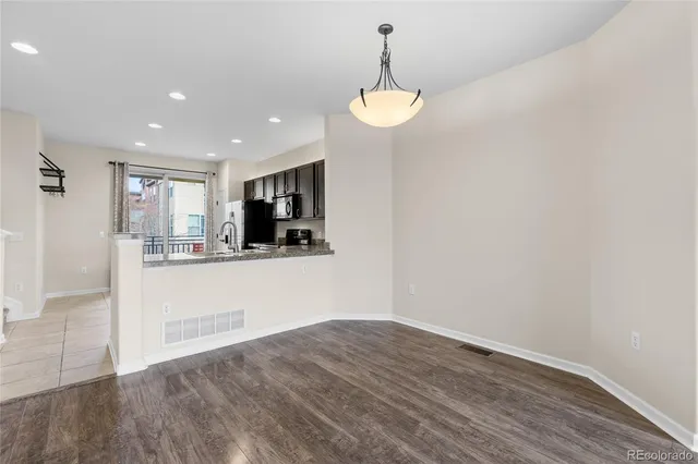 a view of a kitchen with a sink and dishwasher with wooden floor