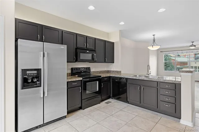 a kitchen with stainless steel appliances granite countertop a refrigerator and a stove top oven