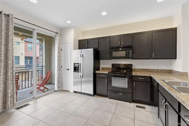 a kitchen with stainless steel appliances granite countertop a refrigerator stove and sink