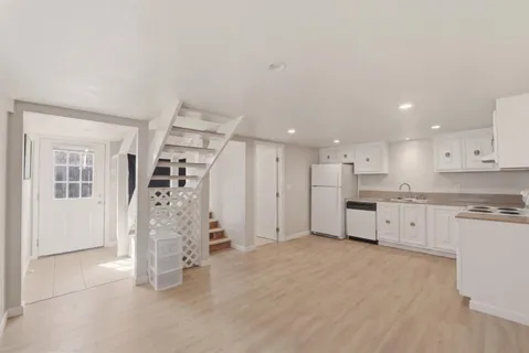 a large white kitchen with white cabinets and stainless steel appliances