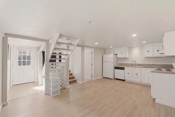 a large white kitchen with white cabinets and stainless steel appliances