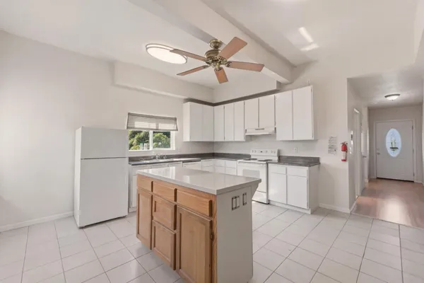 a kitchen with a stove a refrigerator and white cabinets