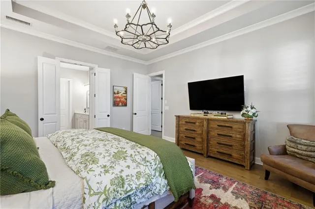 a bedroom with a bed and a chandelier