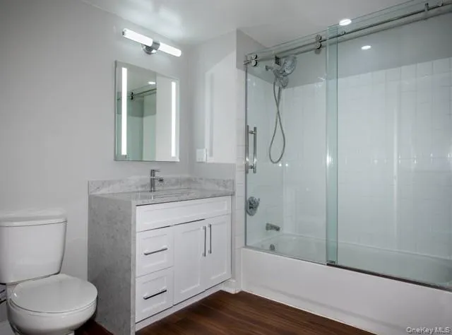 a bathroom with a granite countertop toilet a sink and shower