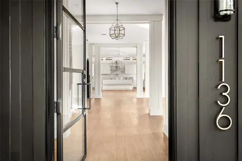 a view of a hallway with wooden floor and windows