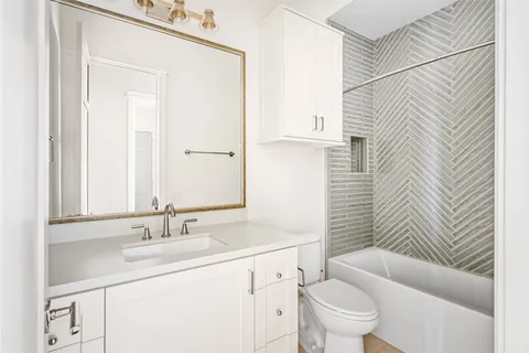 a bathroom with a sink toilet vanity and tub