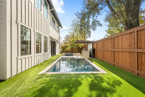 a view of backyard with swimming pool and wooden fence