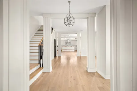 a view of a hallway with wooden floor and staircase