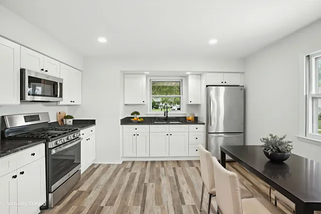 a kitchen with granite countertop a refrigerator stove and sink