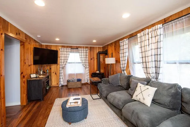 a kitchen with stainless steel appliances granite countertop a refrigerator a stove top oven and a dining table with wooden floor