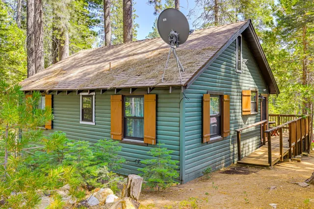 a large kitchen with stainless steel appliances a stove a refrigerator a sink dishwasher with a dining table and chairs with wooden floor