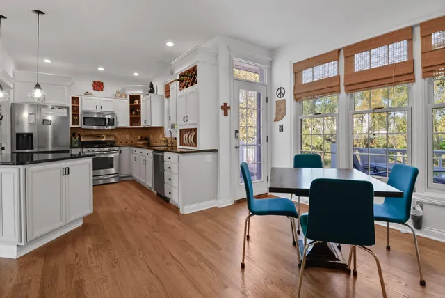 a kitchen with stainless steel appliances kitchen island granite countertop a stove a refrigerator a kitchen island with a dining table and chairs