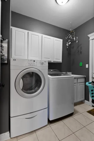 a utility room with cabinets washer and dryer