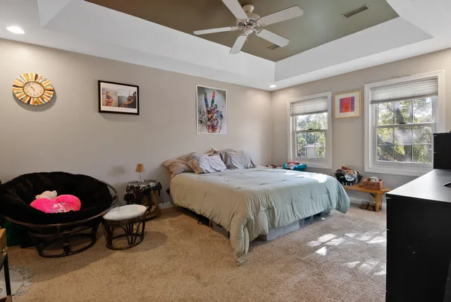 a spacious bedroom with a bed and a chandelier