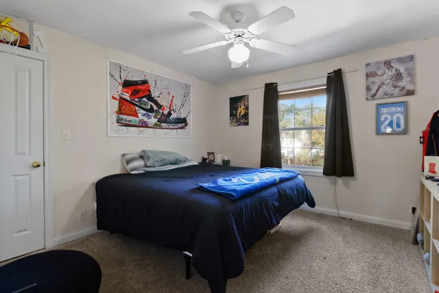 a bedroom with a bed dresser and window