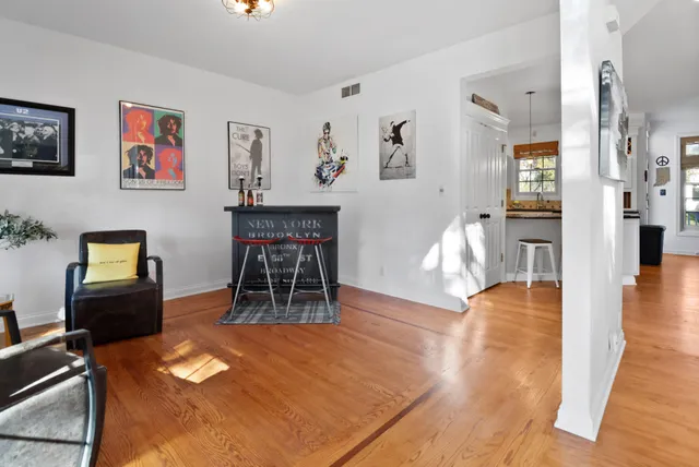 a living room with furniture a dining table and wooden floor
