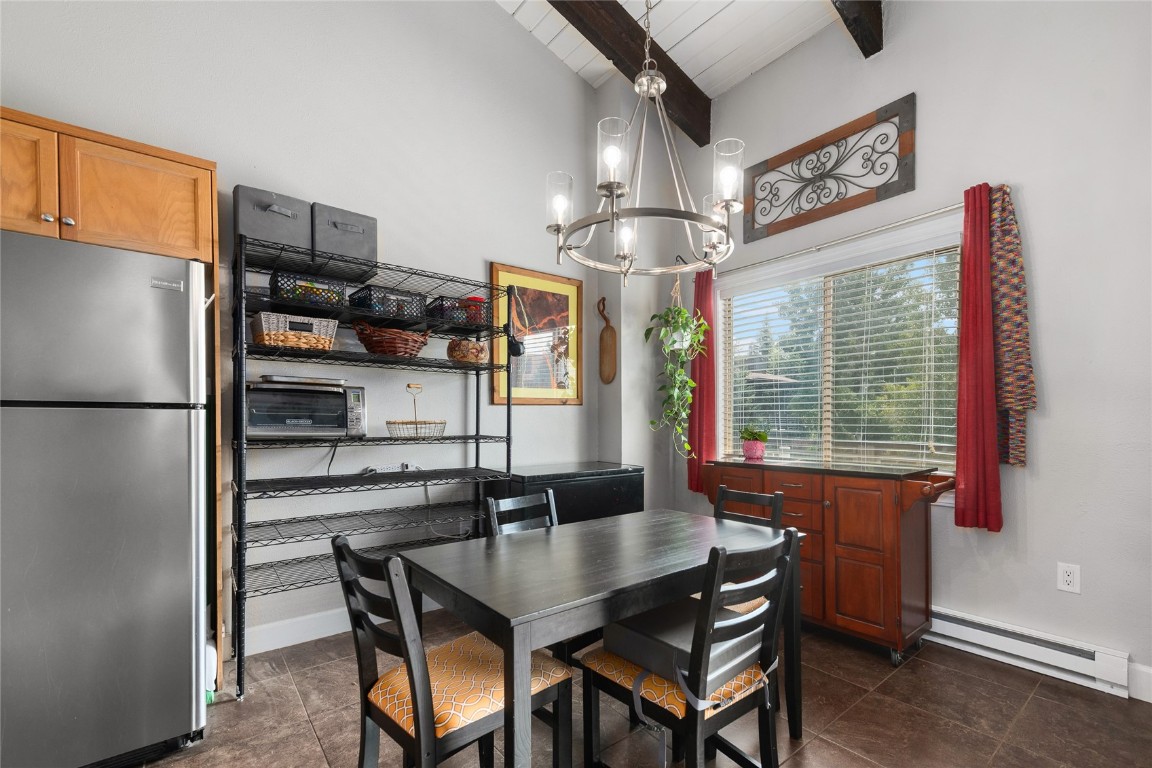1355 Walton Creek Road, Unit 20 Steamboat Springs, CO 80487 - Photo 14 of 43 a dining room with stainless steel appliances kitchen island granite countertop furniture and a chandelier