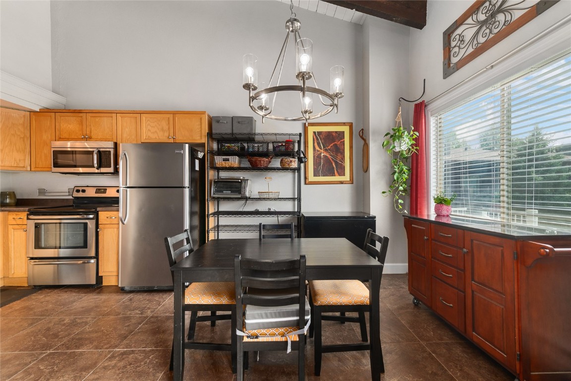 1355 Walton Creek Road, Unit 20 Steamboat Springs, CO 80487 - Photo 15 of 43 a kitchen with granite countertop a refrigerator cabinets dining table and chairs