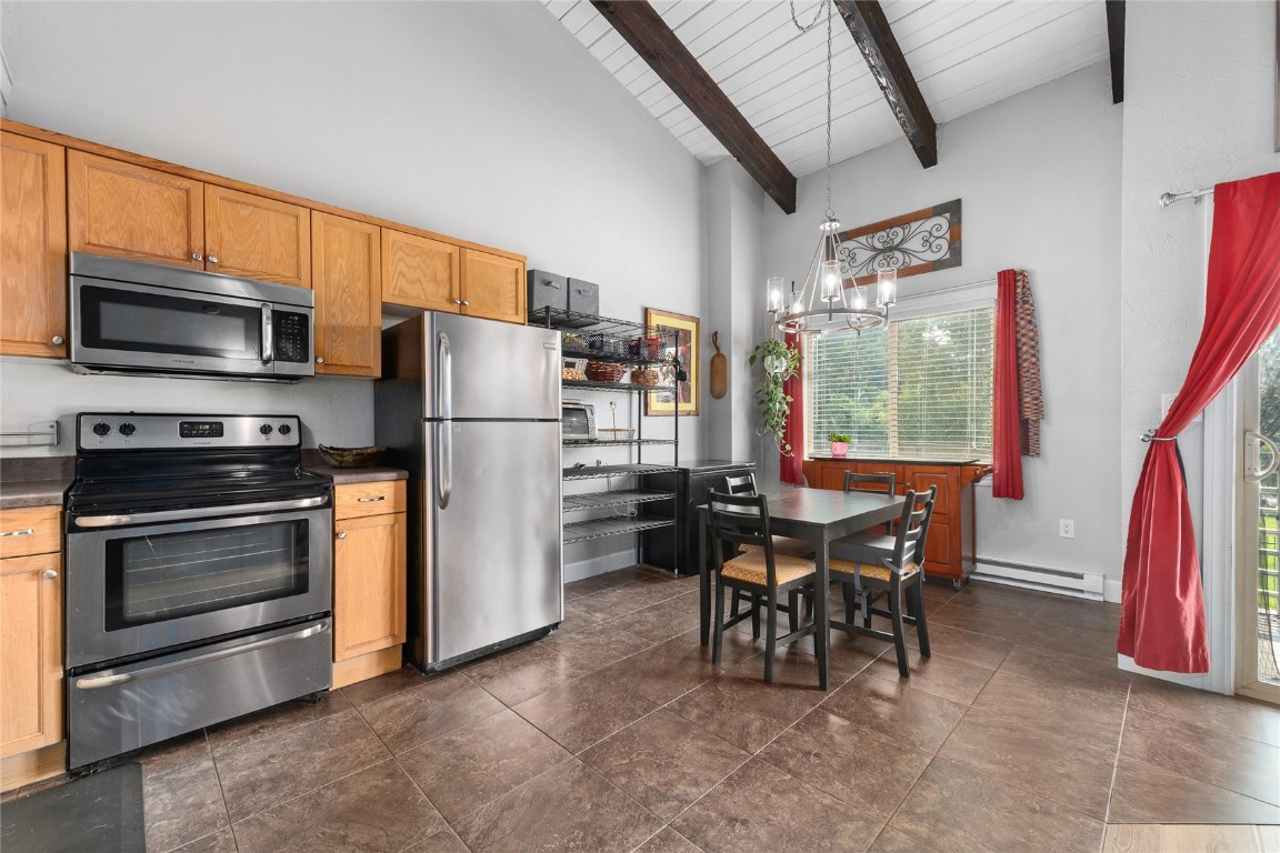 1355 Walton Creek Road, Unit 20 Steamboat Springs, CO 80487 - Photo 18 of 43 a kitchen with a table chairs stainless steel appliances and cabinets