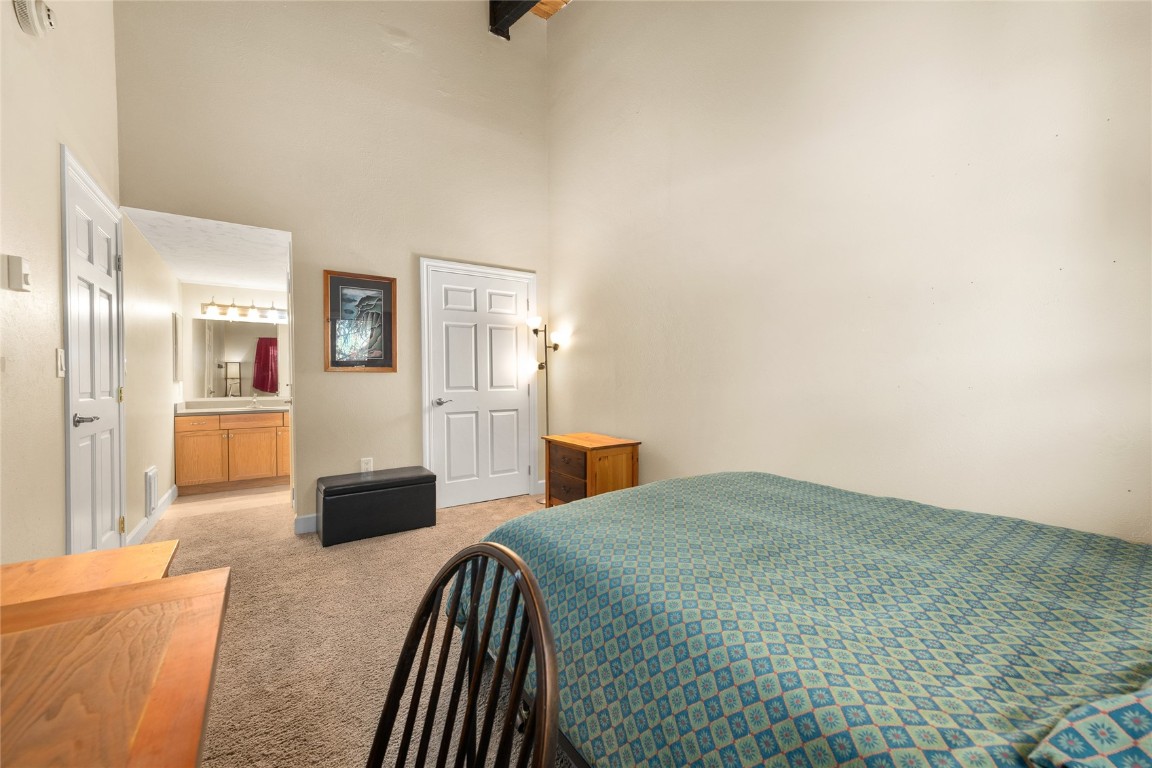 1355 Walton Creek Road, Unit 20 Steamboat Springs, CO 80487 - Photo 33 of 43 a bedroom with a bed and a view of bathroom