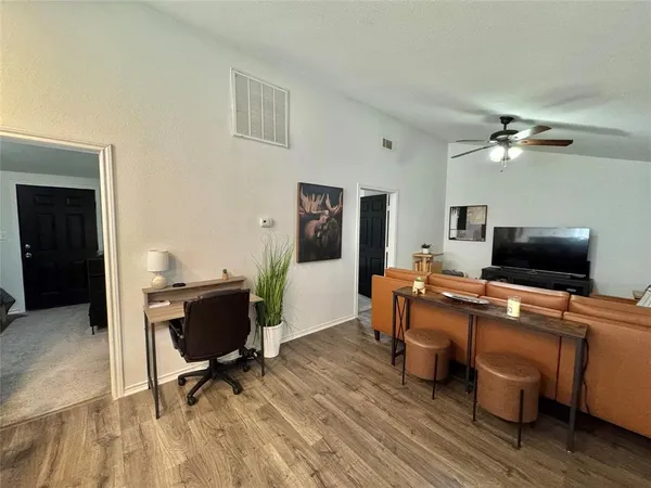 a view of a workspace with furniture and a window