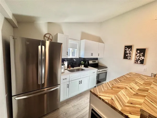 a kitchen with stainless steel appliances granite countertop a refrigerator and a stove top oven