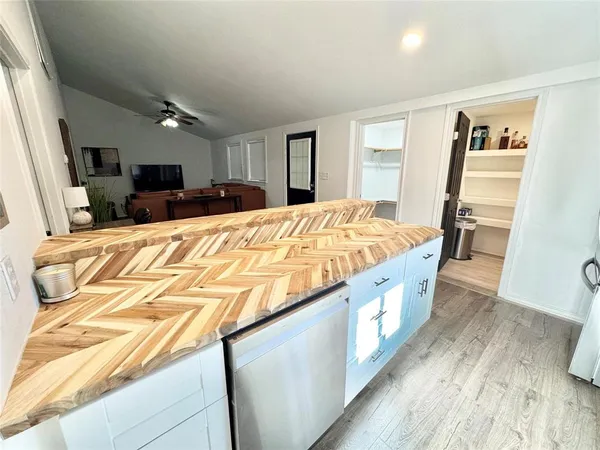 a large bedroom with kitchen island a bed and wooden floor