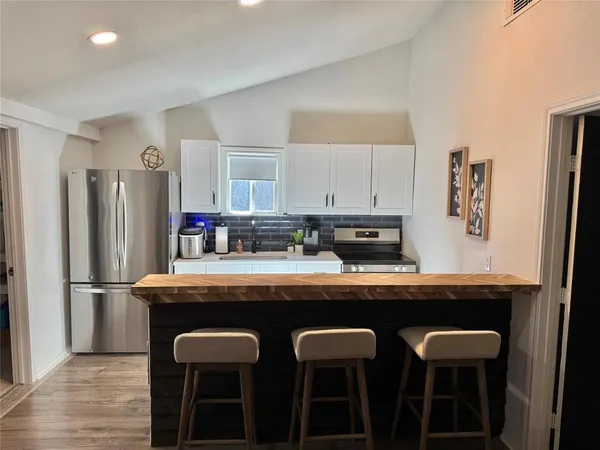 a kitchen with kitchen island cabinets and refrigerator