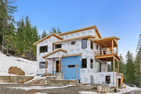 a view of a white house with large windows and a small yard