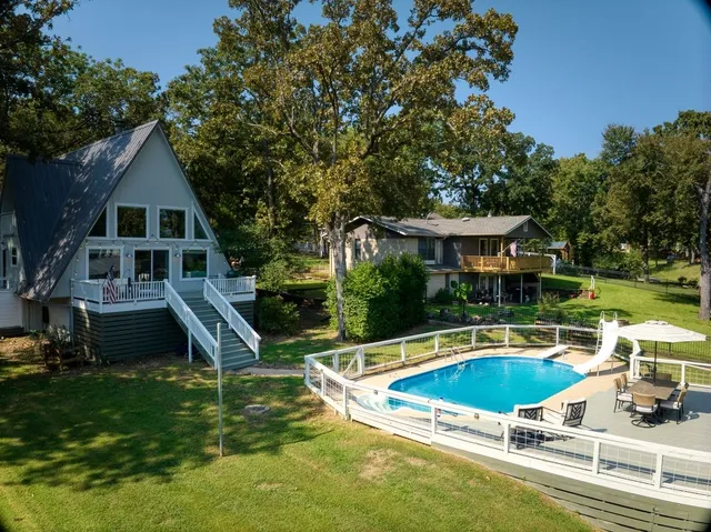 a view of a house with pool and chairs