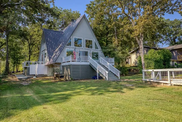 a view of house with deck outdoor seating and wooden floor