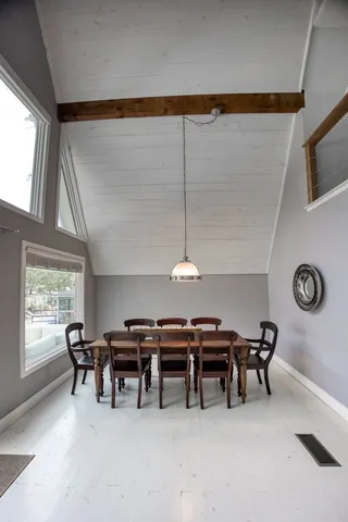 a kitchen with a dining table chairs cabinets and stainless steel appliances