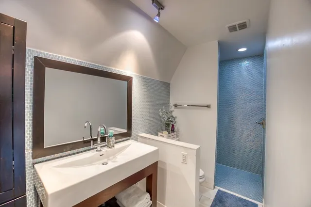 a bathroom with a sink a toilet and shower